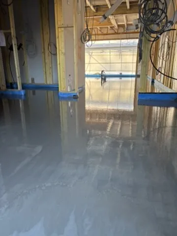 Liquid screed drying inside the test project — the kind of progress a drawdown application claims for.